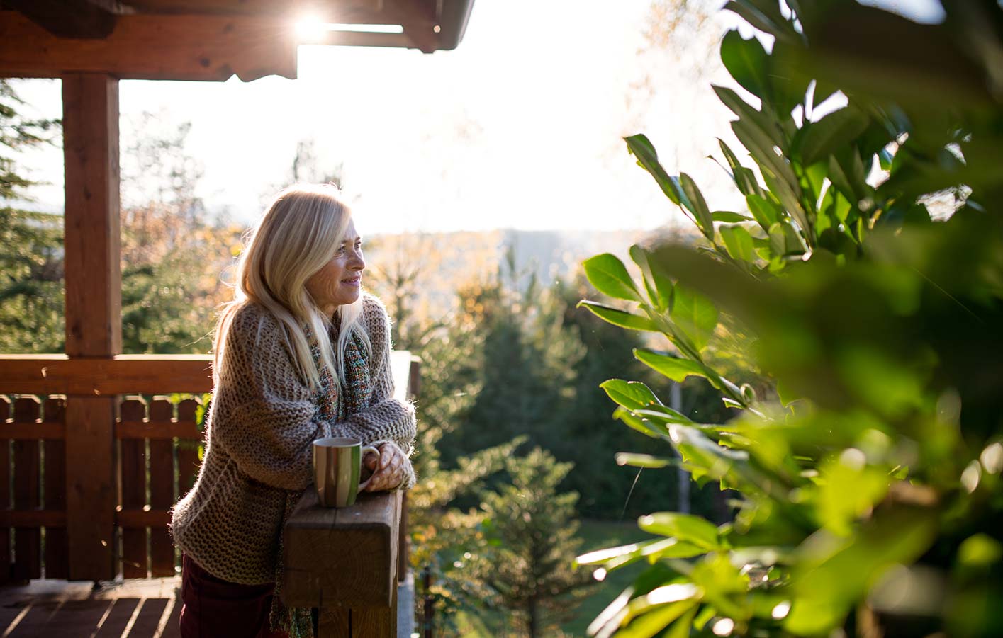 Massivholz-Gartenhaus für mehr entspannte Momente Frau auf Terrasse vom Massivholzhaus, Gartenhaus